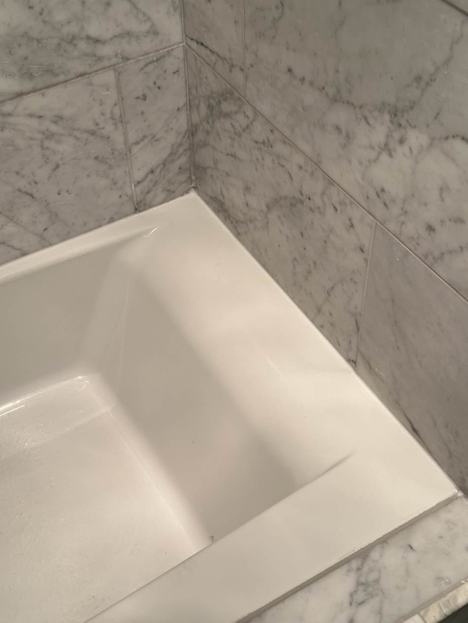 Clean bathtub corner with a fresh flexible caulk seal in West LA, CA 90025
