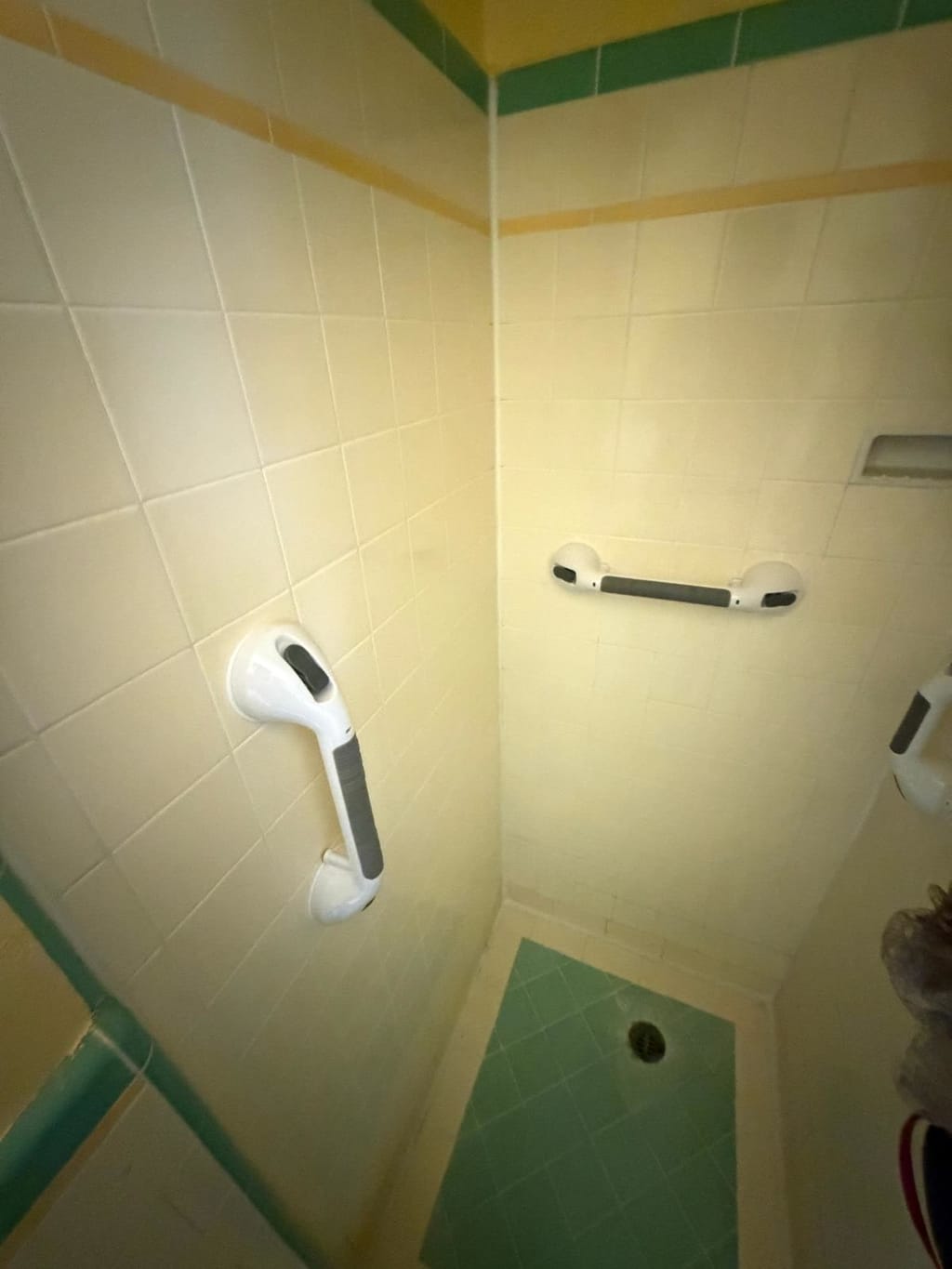 Old suction-cup grab bars stuck to the tile in a shower before a permanent install in Beverlywood, CA 90035