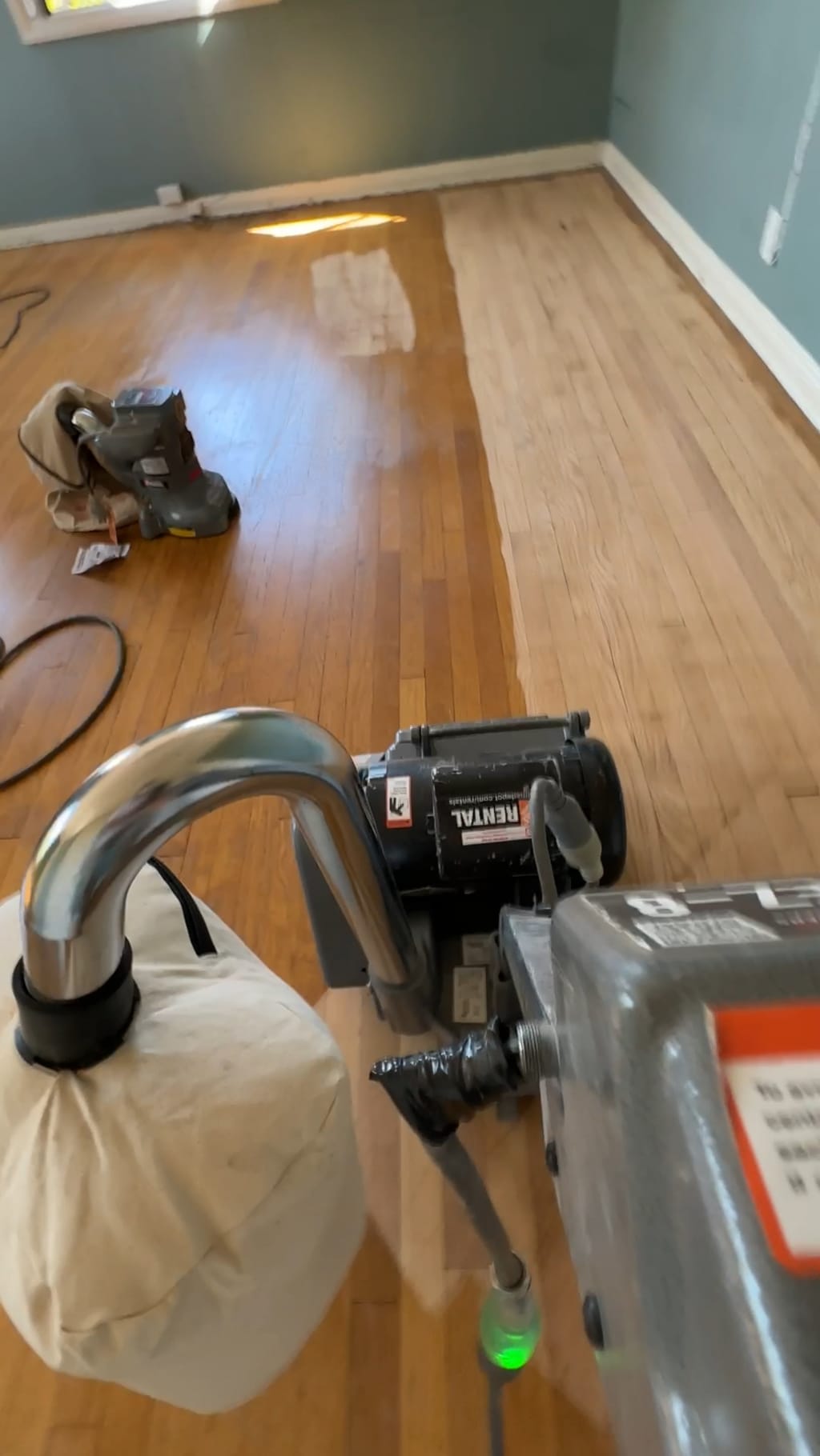 Drum sander stripping the old finish, half the floor already back to bare wood in Beverlywood, CA 90035