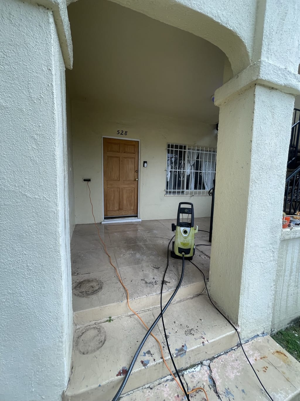 Unit porch with stained, worn concrete before painting in Mid-City, CA 90036