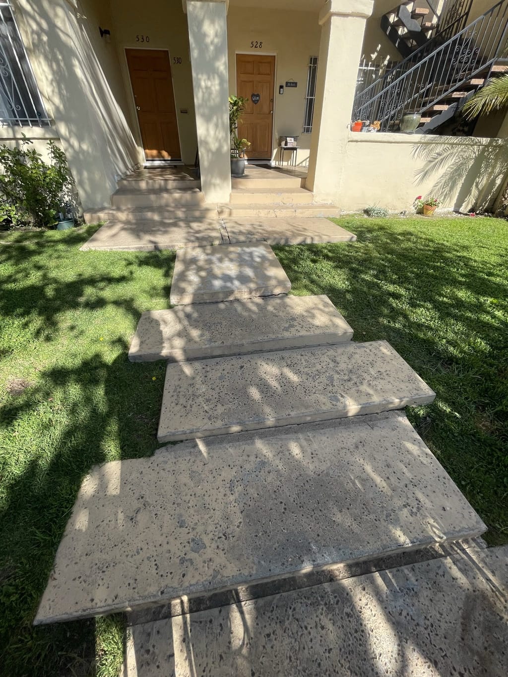 Worn, gray, cracked concrete entry walkway and steps before painting in Mid-City, CA 90036