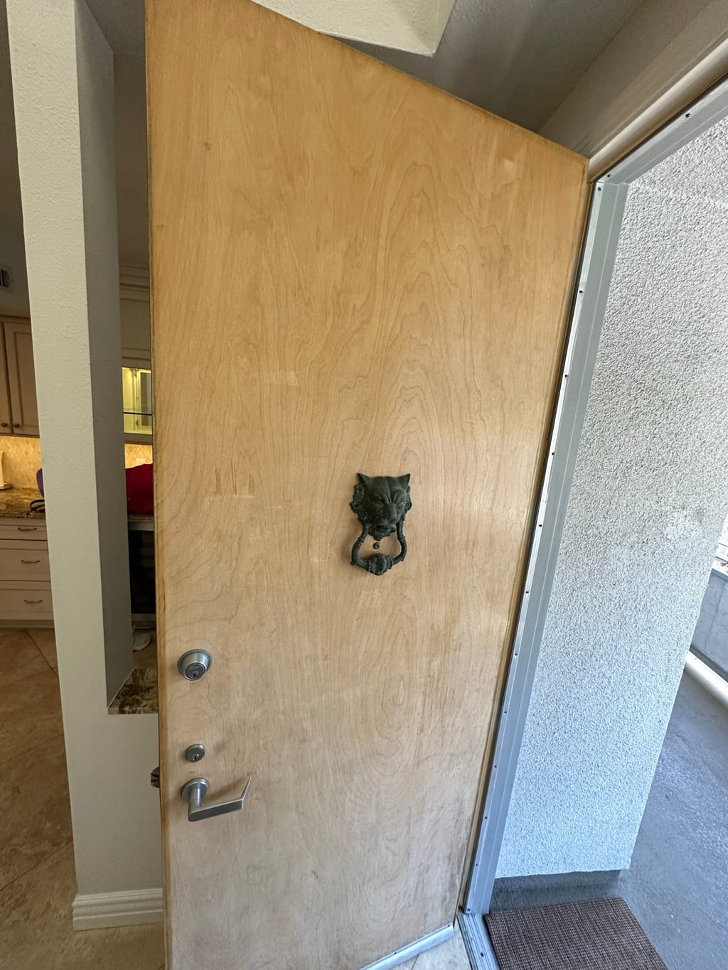 Veneer entrance door with a worn, darkening finish before restaining in Brentwood, CA 90049