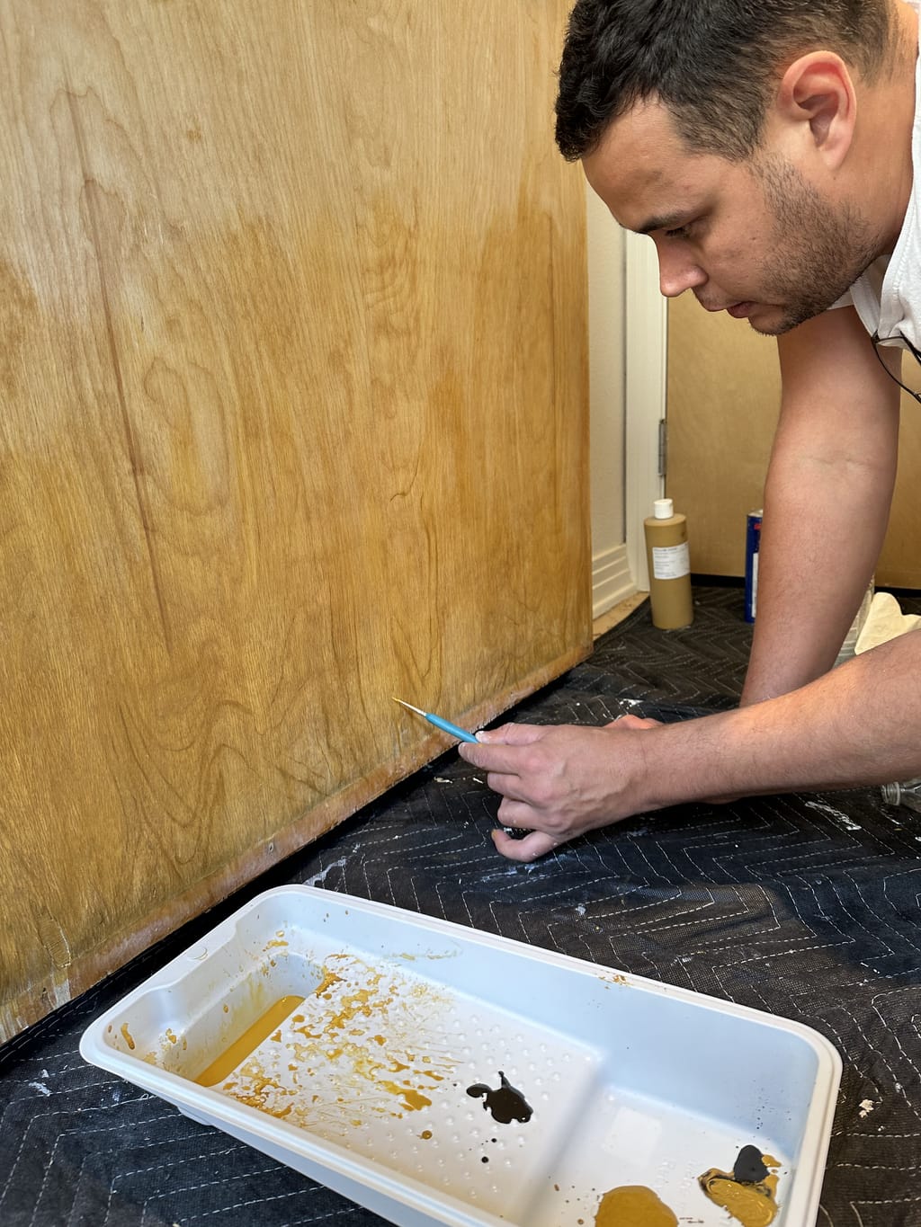 Rebuilding worn wood grain by hand with a fine brush on an entrance door in Brentwood, CA 90049