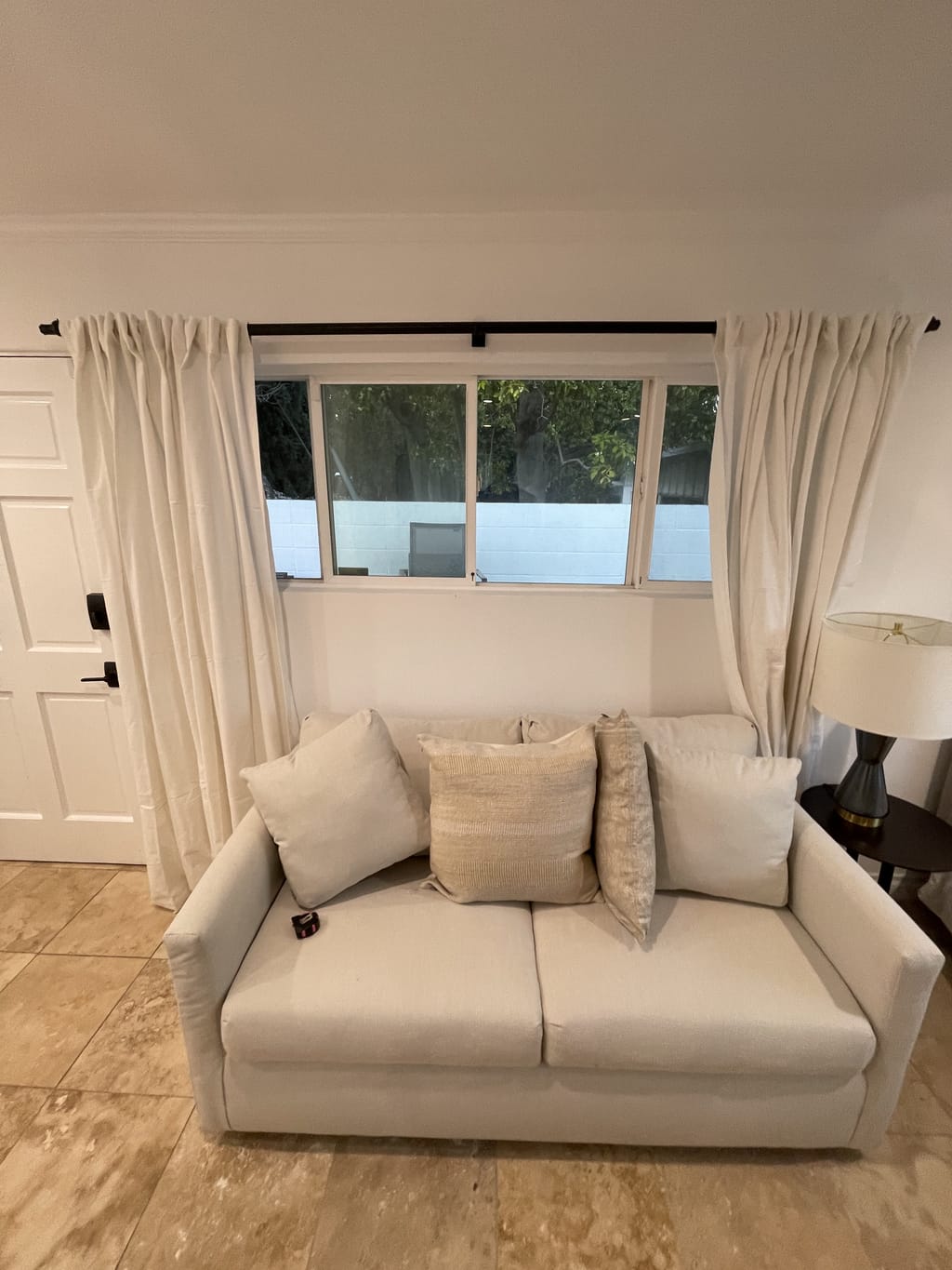 Linen curtains installed on a black rod over a living area window in Bel Air, CA 90077