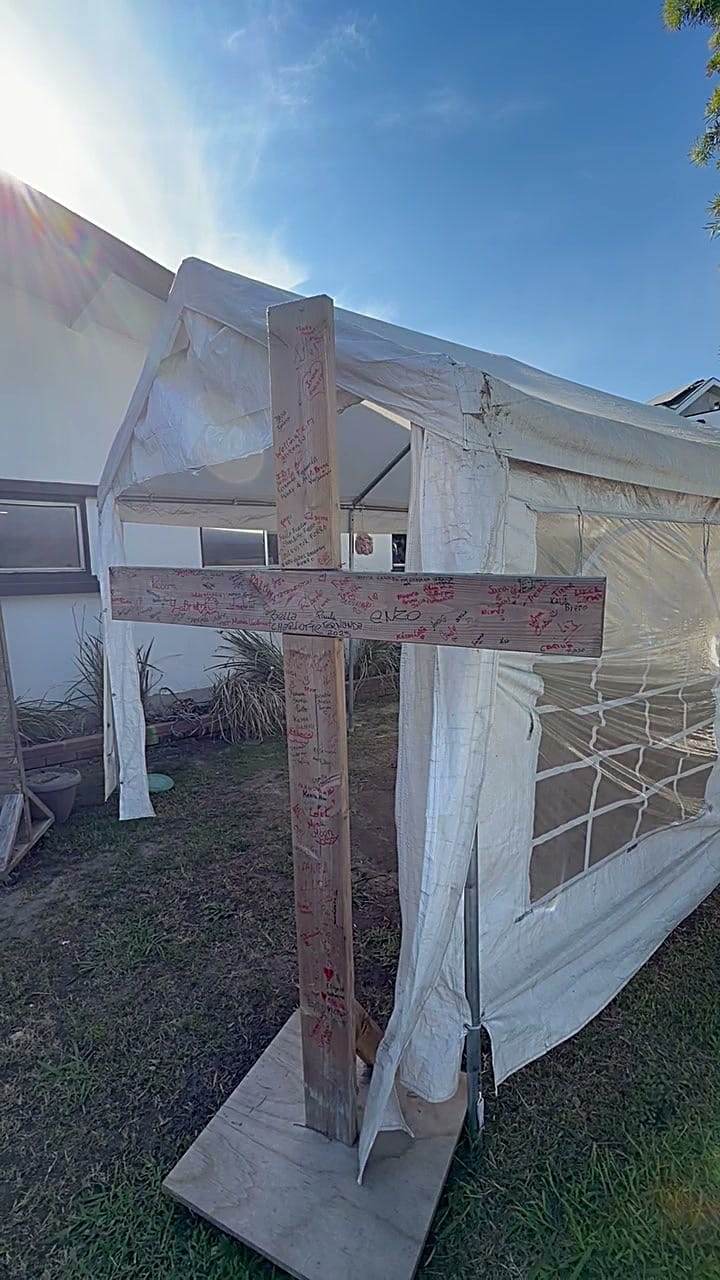 Weathered wood cross covered in handwritten names before restaining in Culver City, CA 90232