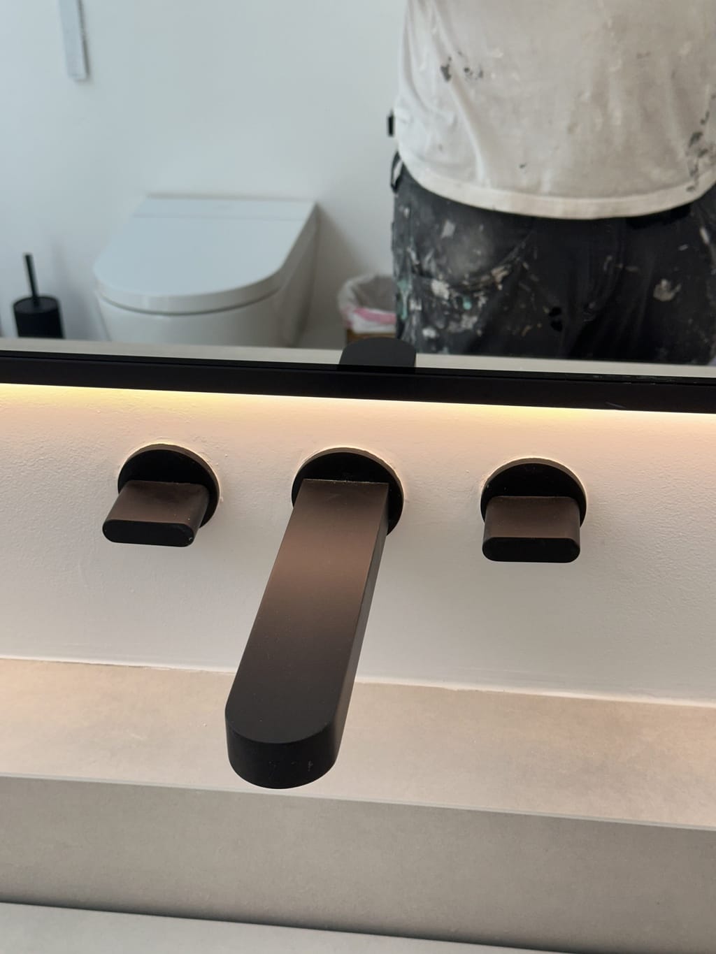 Clean, smooth wall finish around a black wall-mounted faucet set in Malibu, CA 90265
