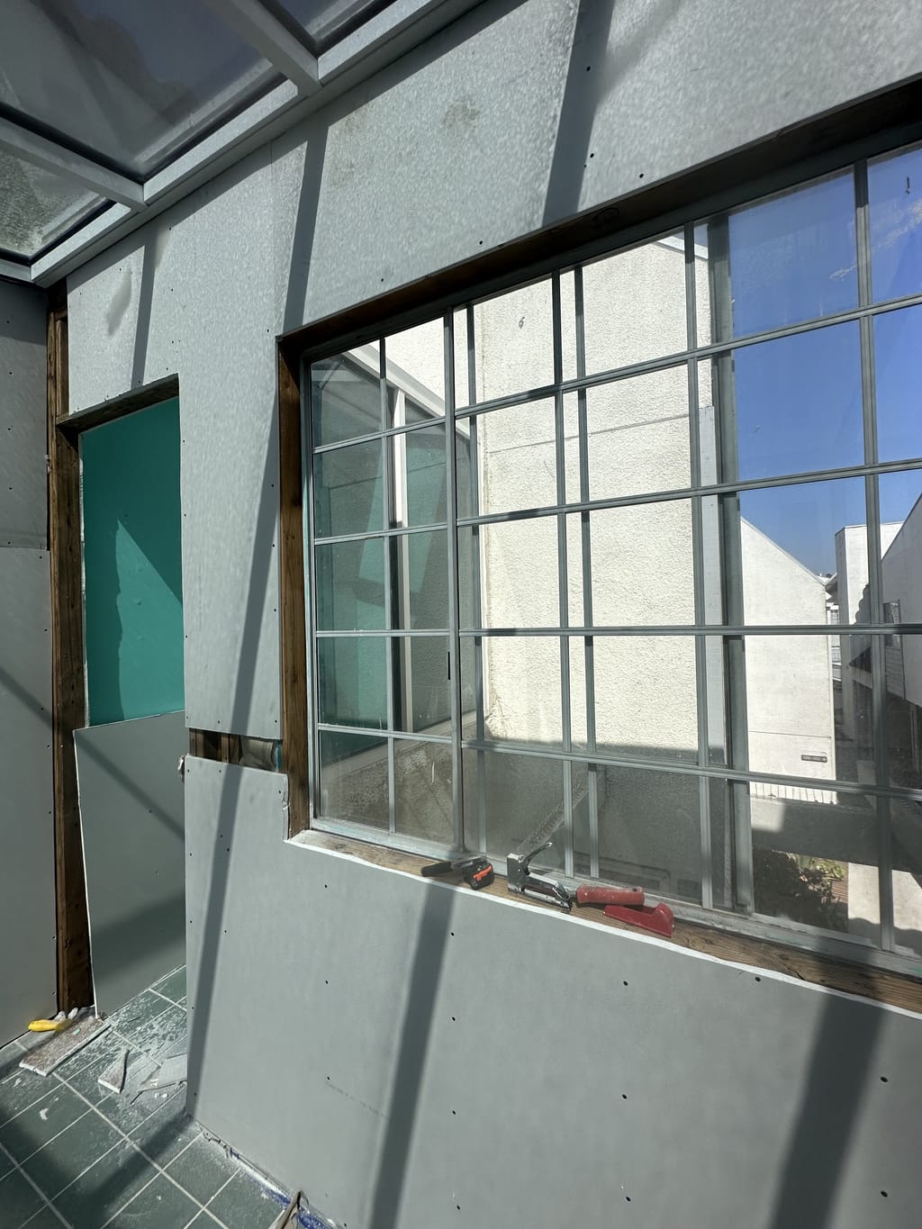 New drywall installed around a window with the glass masked off in Glendale, CA 91207