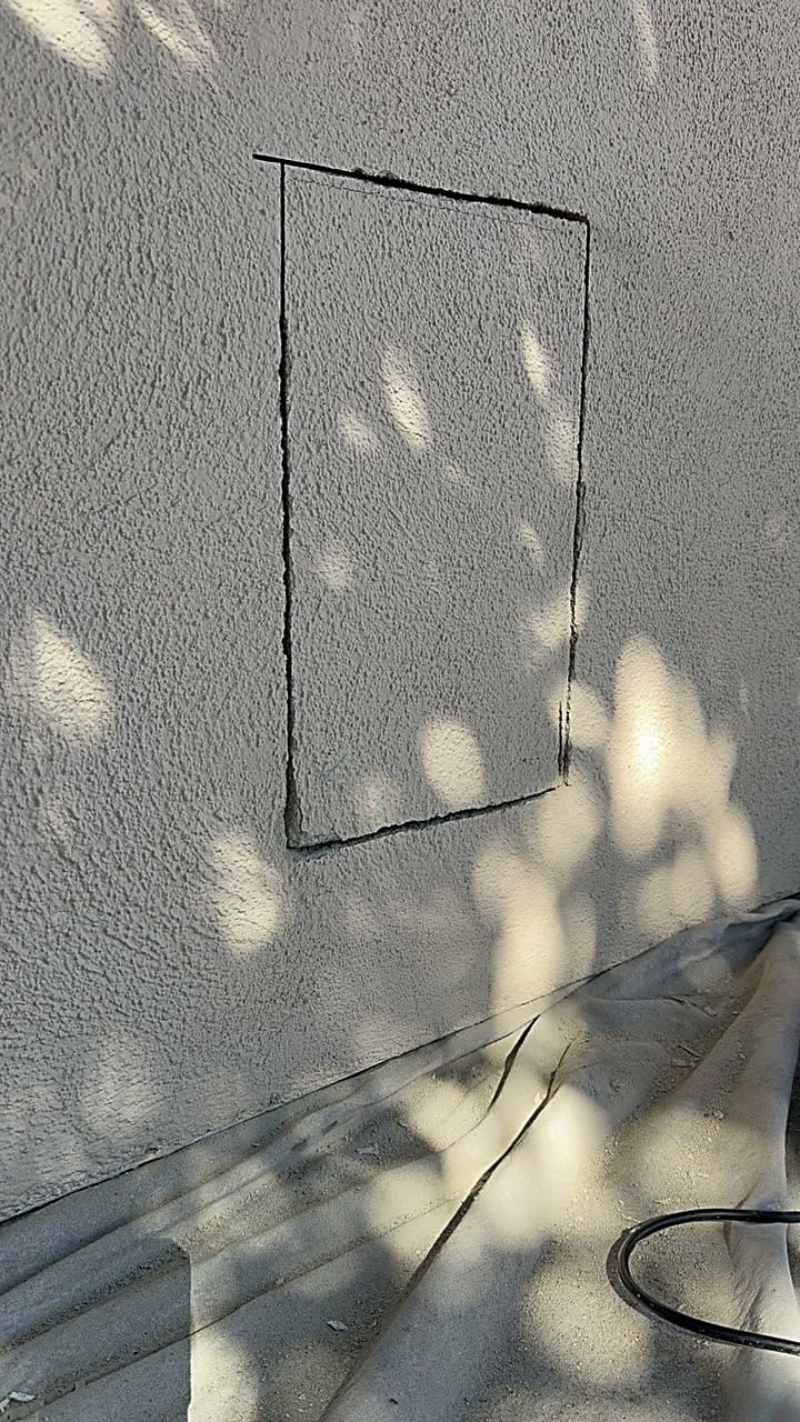 Marked and cut opening for a dog door in an exterior stucco wall in Canoga Park, CA 91303