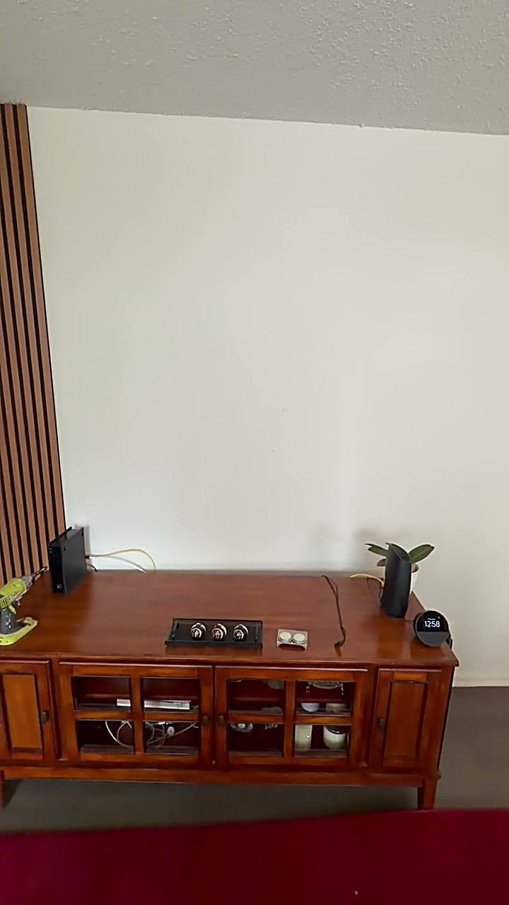 Blank living-room wall above a wood media console before the media wall install in Burbank, CA 91506