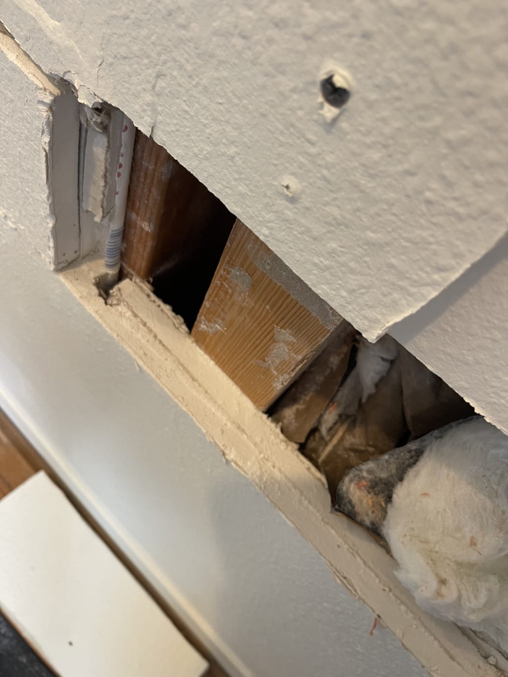 Close-up of a drywall opening showing exposed wood stud, insulation and plumbing in Venice, CA 90291